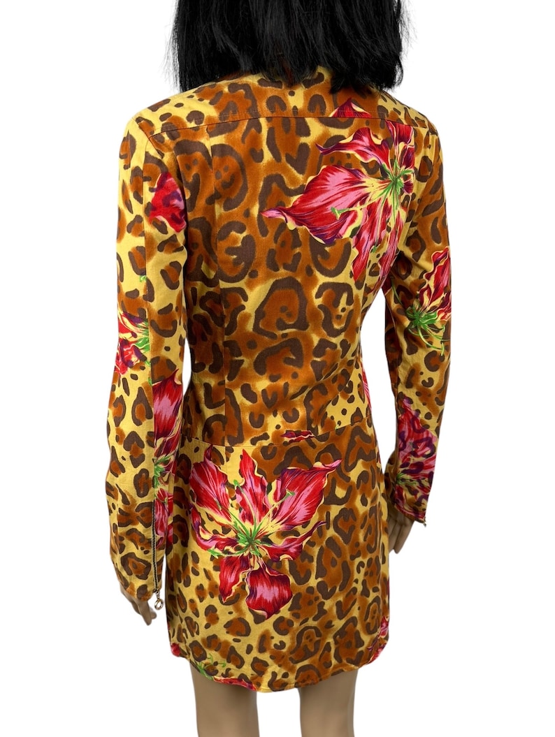 May include: A yellow, brown and red patterned dress with long sleeves and a zip closure. The dress features a leopard print and large red flowers.