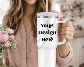 Puede incluir: Vaso blanco con asa y pajita, con el texto "Your Design Here" en negro. El vaso lo sostiene una persona. El vaso está diseñado para contener bebidas frías o calientes.