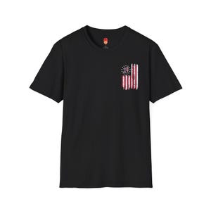 Op de afbeelding: Zwart T-shirt met korte mouwen met een verweerde Amerikaanse vlag afbeelding op de linker borst. De vlag heeft de nummers 45 en 47 in de sterren.