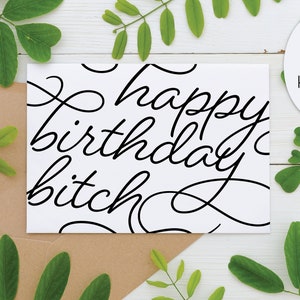 May include: A white birthday card with the words "happy birthday bitch" in black script. The card is in a brown envelope, with green leaves and the words "PRINT AT HOME" in a white circle.