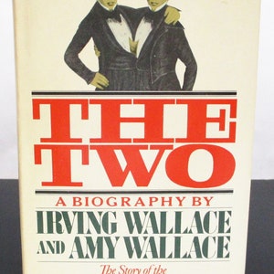 May include: Book cover with a red and white title "THE TWO" and the subtitle "A BIOGRAPHY BY IRVING WALLACE AND AMY WALLACE". The cover also features a black and white illustration of two men standing side-by-side, with the text "The Story of the Original Siamese Twins" at the bottom.