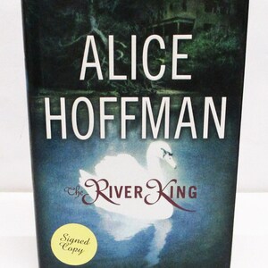 May include: A hardcover book titled "The River King" by Alice Hoffman. The cover features a white swan on a blue water background, with the title in a stylized font. A yellow sticker reads "Signed Copy".