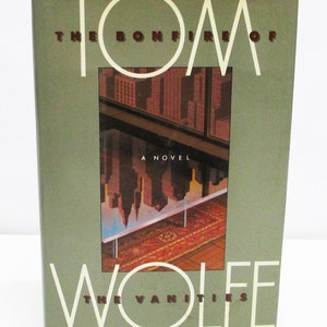 May include: A green book cover with the title "The Bonfire of the Vanities" by Tom Wolfe. The cover features a stylised illustration of a city reflected in a glass table.