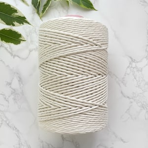 May include: A spool of natural white cotton cord, ideal for crafting projects.