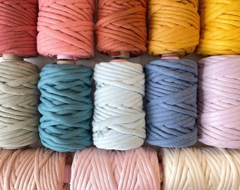 Könnte beinhalten: Eine Sammlung von zehn Spulen mit Baumwollseil in verschiedenen Farben, darunter Salbeigrün, Teal, Hellblau, Denimblau, Lavendel, Blush Pink, Creme und Terrakotta.