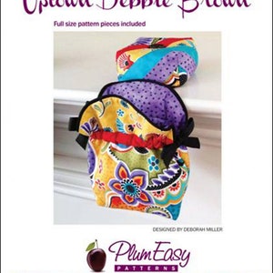 May include: A sewing pattern for a thread bag and pin cushion set. The pattern is called "Uptown Debbie Brown" and is designed by Deborah Miller. The pattern is from Plum Easy Patterns.