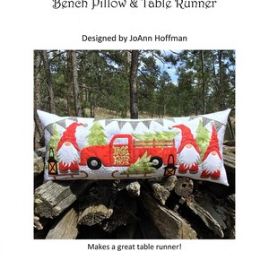 May include: A red truck with a Christmas tree on the back, two gnomes, and the text "Tree Farm" is featured on a bench pillow. The pillow is 16 inches by 38 inches and is made with a raw edge applique technique.