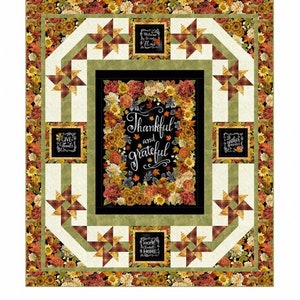May include: A quilt pattern featuring a black background with a floral wreath and the text "Thankful and grateful". The quilt is surrounded by a green and red plaid border with a white background.