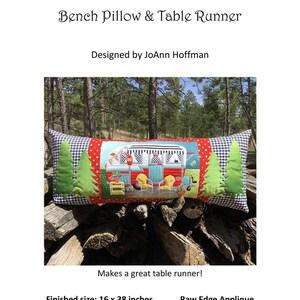 May include: A red, white, and blue camper van applique on a black and white checkered fabric bench pillow. The pillow is 16 inches by 38 inches and is made with a raw edge applique technique. The pillow is displayed on a pile of logs in a forest setting.