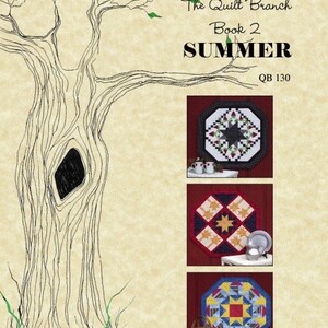 May include: Table Topper Series, The Quilt Branch, Book 2, Summer, QB 130.  A book cover featuring a tree with a hole in the trunk and three quilt designs. The quilts are octagonal and feature a variety of colors and patterns.