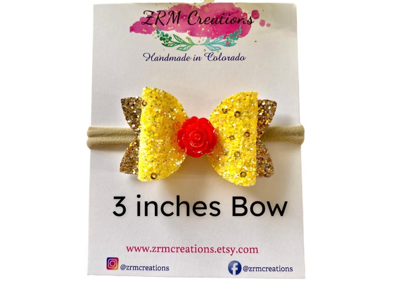 K&ouml;nnte beinhalten: Ein 7,6 cm gro&szlig;er gelber Glitzerbogen mit einer roten Blumenmitte auf einem hautfarbenen Haarreif. Der Haarreif wird auf einer wei&szlig;en Karte mit dem Text "ZRM Creations Handmade in Colorado" und der Website-Adresse "www.zrmcreations.etsy.com" gezeigt.