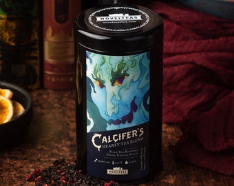 May include: A black metal tea tin with a blue and green illustration of a fire demon. The tin is labeled "Calcifers Hearty Tea Blend" and features the text "Black Tea, Raspberries,  Peaches, Natural Flavor" and "Novelteas.com".