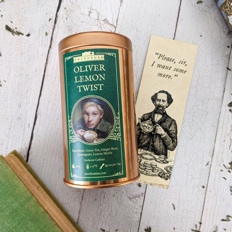 May include: A copper tin of Oliver Lemon Twist tea with a green label and a picture of a young person holding a cup. The label says "Novelteas" and lists the ingredients: Green Tea, Ginger Root, Lemongrass, Lemon Myrtle. The label also says "Moderate Caffeine" and "1/2 tsp per cup".