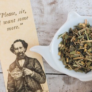 May include: A white ceramic teapot with a quote on a yellow card that reads "Please, sir, I want some more."