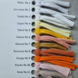 May include: A color chart with 11 fabric swatches, each labeled with a color name and number. The colors range from white to nude.