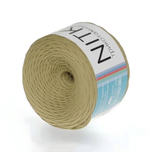May include: A spool of light brown cotton yarn with a label that reads "NITK -  ТРИКОТАЖНАЯ". The label also includes care instructions.