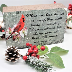May include: A rectangular stone-like plaque featuring a vibrant red cardinal perched on white blossoms. The text reads: Those we love do not go away, they walk beside us everyday. Unseen, unheard but always near, still loved, still missed and very dear.
