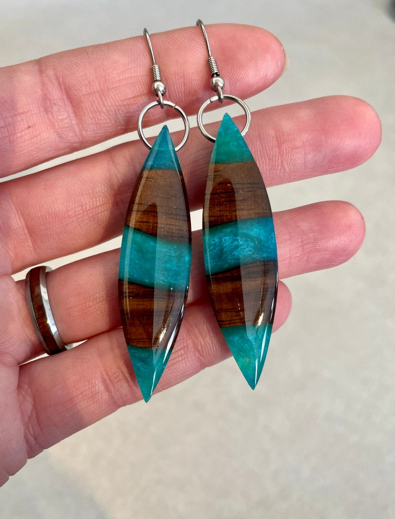 May include: Teal and brown wood resin earrings with silver hooks.
