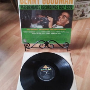 May include: A vintage vinyl record album cover featuring Benny Goodman and his orchestra, trio, and quartet. The cover is green, yellow, and black with the text "Benny Goodman Performance Recordings 1937-1938" and "The Original Orchestra, Trio and Quartet".