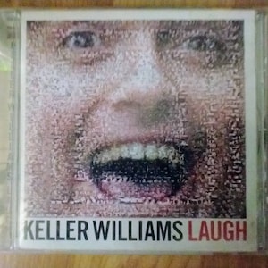 May include: A CD case with a close-up image of a person's face with a distorted, pixelated effect. The person is laughing with their mouth open and teeth showing. The text "KELLER WILLIAMS LAUGH" is printed on the front of the case.