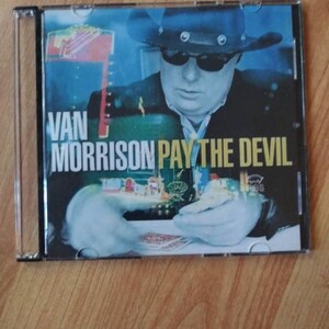 May include: A CD case with a blue background featuring a man wearing a black cowboy hat and sunglasses. The text "VAN MORRISON PAY THE DEVIL" is printed in white on the case.