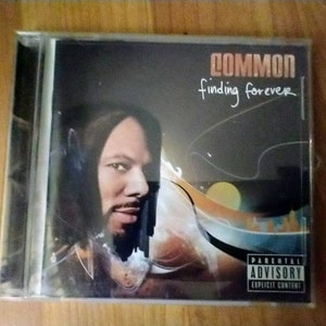 May include: A CD case with a black and white photo of a man on the front. The title of the album is "Common finding forever" and the album cover has a Parental Advisory sticker.