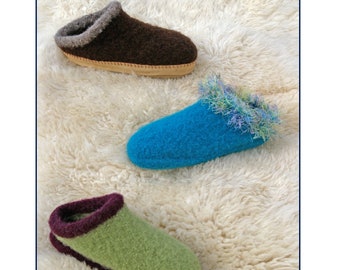 May include: Three felt clogs in brown, blue, and green are displayed on a white, fluffy surface. The clogs have contrasting trim and soles. The top of the image reads "Fiber Trends" and "Felt Clogs".