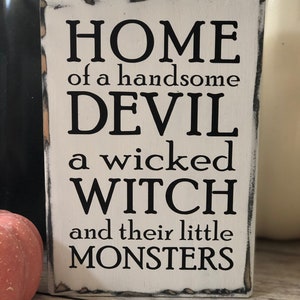Dom przystojnego diabła, złej czarownicy i ich potworów, dom wiejski, osoby siedzące na półce, znak Halloween