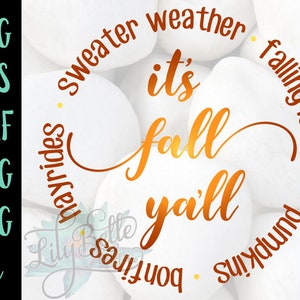 May include: A digital design featuring the text "It's fall y'all" in a gold script font. The text is surrounded by a circle of white stones with the words "sweater weather", "falling leaves", "hayrides", "bonfires", and "pumpkins" written around the circle.