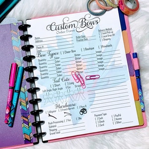 May include: A pink and white planner with a custom bow order form. The form includes sections for bow types, tail cuts, hardware, rush processing, subtotal, shipping, and grand total. The form also includes sections for delivery method, payment type, and other details.