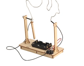 May include: A wooden handheld game with a metal wire shaped like a hand. The game has two wooden posts, a battery holder, and a small black speaker. The wire loop must be guided without touching the wire.