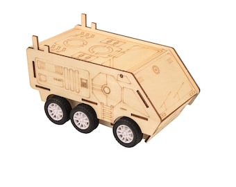 May include: A wooden toy truck with a detailed design. The truck is made of light brown wood and has four wheels. The truck is a model of a military vehicle.