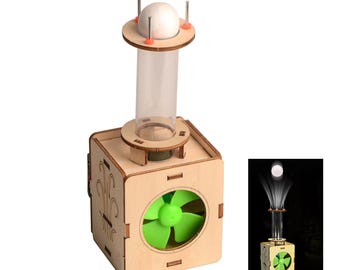 May include: A wooden educational toy with a clear tube and a green fan. A white ball sits atop the tube, held in place by metal rods. The toy is designed to demonstrate airflow principles. The base is a wooden cube.
