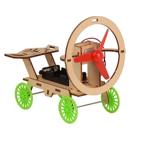 May include: A wooden toy car with a red propeller and green wheels. The car has a battery compartment and a small seat. The propeller is attached to a circular frame.