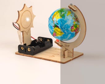 May include: A wooden model of the Earth and Sun, with a globe tilted on an axis and a light-up sun. The model is designed to demonstrate the Earth's rotation and revolution around the Sun.