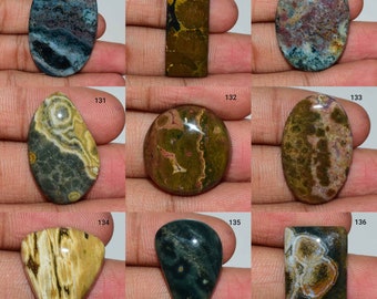 May include: Ten oval, round, and teardrop shaped cabochons of green, brown, and blue ocean jasper. The stones are polished and have a variety of patterns and colours.