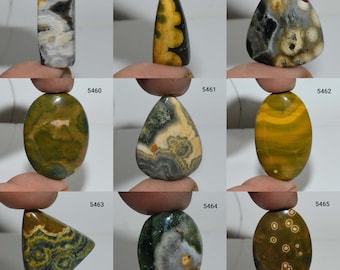 May include: Nine different cabochon gemstones, each with unique patterns and colours, including green, yellow, brown, and black. The gemstones are arranged in a grid of three rows and three columns.