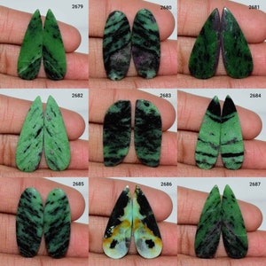 Puede incluir: Nueve pares de cabujones de piedras preciosas verdes, negras y blancas. Los cabujones son de varias formas y tamaños, incluyendo ovalados, en forma de pera y en forma de lágrima. Los cabujones están dispuestos en tres filas de tres pares.