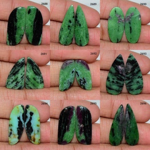 Peut inclure: Dix paires de cabochons de pierres précieuses vertes, noires et violettes. Les cabochons sont de formes variées, notamment en forme de larme, ovale et poire. Les cabochons sont disposés par paires, chaque paire étant étiquetée d'un numéro.