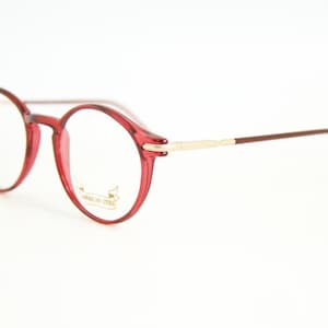 May include: Red round glasses with gold accents and the text "American Optical" on the frame.
