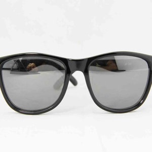 May include: Black sunglasses with mirrored lenses. The sunglasses have a classic wayfarer style frame.
