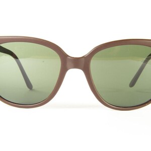 May include: Brown plastic framed sunglasses with green lenses.