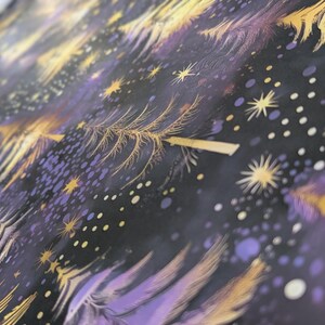 May include: Purple and gold fabric with a repeating pattern of stylized trees and stars. The fabric has a soft, brushed texture.