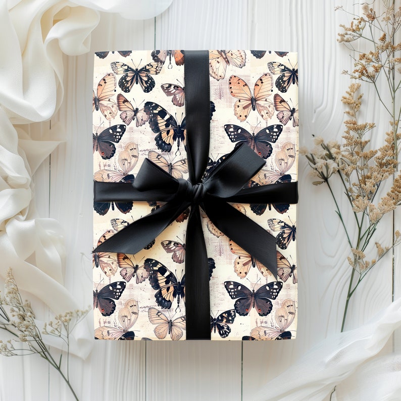 May include: A gift box wrapped in white paper with a black ribbon and a pattern of brown and black butterflies.