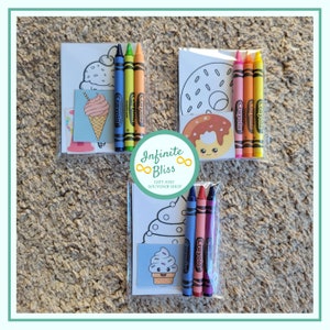 May include: Three clear plastic bags each containing a coloring page and four crayons. The coloring pages feature a donut, an ice cream cone, and a cupcake. The crayons are red, orange, yellow, and blue. The bags are labeled "Infinite Bliss Gift and Souvenir Shop".