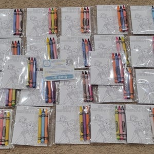 K&ouml;nnte beinhalten: Draufsicht auf mehrere Sets von Malvorlagen und Buntstiften. Jedes Set enth&auml;lt eine Malvorlage mit einem Cartoon-Bild und eine kleine Packung Buntstifte in verschiedenen Farben. Auf den Malvorlagen steht "HAPPY BIRTHDAY".