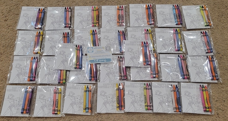 K&ouml;nnte beinhalten: Draufsicht auf mehrere Sets von Malvorlagen und Buntstiften. Jedes Set enth&auml;lt eine Malvorlage mit einem Cartoon-Bild und eine kleine Packung Buntstifte in verschiedenen Farben. Auf den Malvorlagen steht "HAPPY BIRTHDAY".