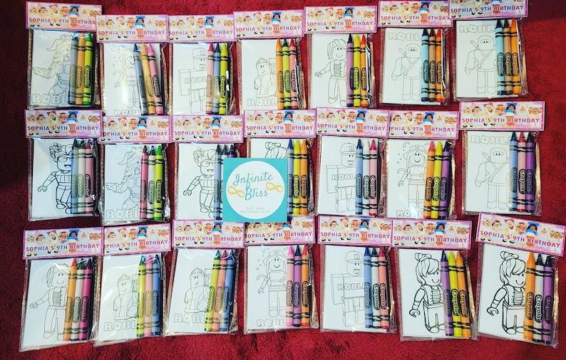 Pu&ograve; includere: Un set di 12 sacchetti per bomboniere, ognuno contenente una pagina da colorare con un personaggio di Roblox e un set di pastelli. I sacchetti sono decorati con il testo "Sophia's 9th Birthday".