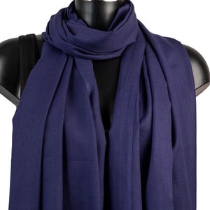 Peut inclure: Une écharpe bleu marine avec une bordure frangée. L'écharpe est faite d'un tissu doux et léger, parfait pour ajouter une touche de couleur à n'importe quelle tenue.