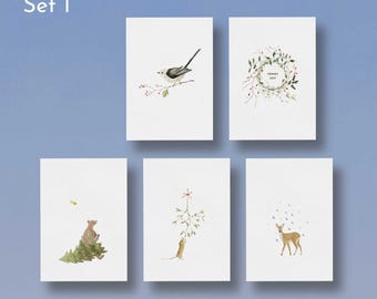 Puede incluir: Un conjunto de cinco tarjetas de felicitación rectangulares blancas etiquetadas como Set 1. Las ilustraciones muestran un mito en una rama, una corona festiva con el texto "FRANCE FEST", un oso con un pino, un ratón y un ciervo.